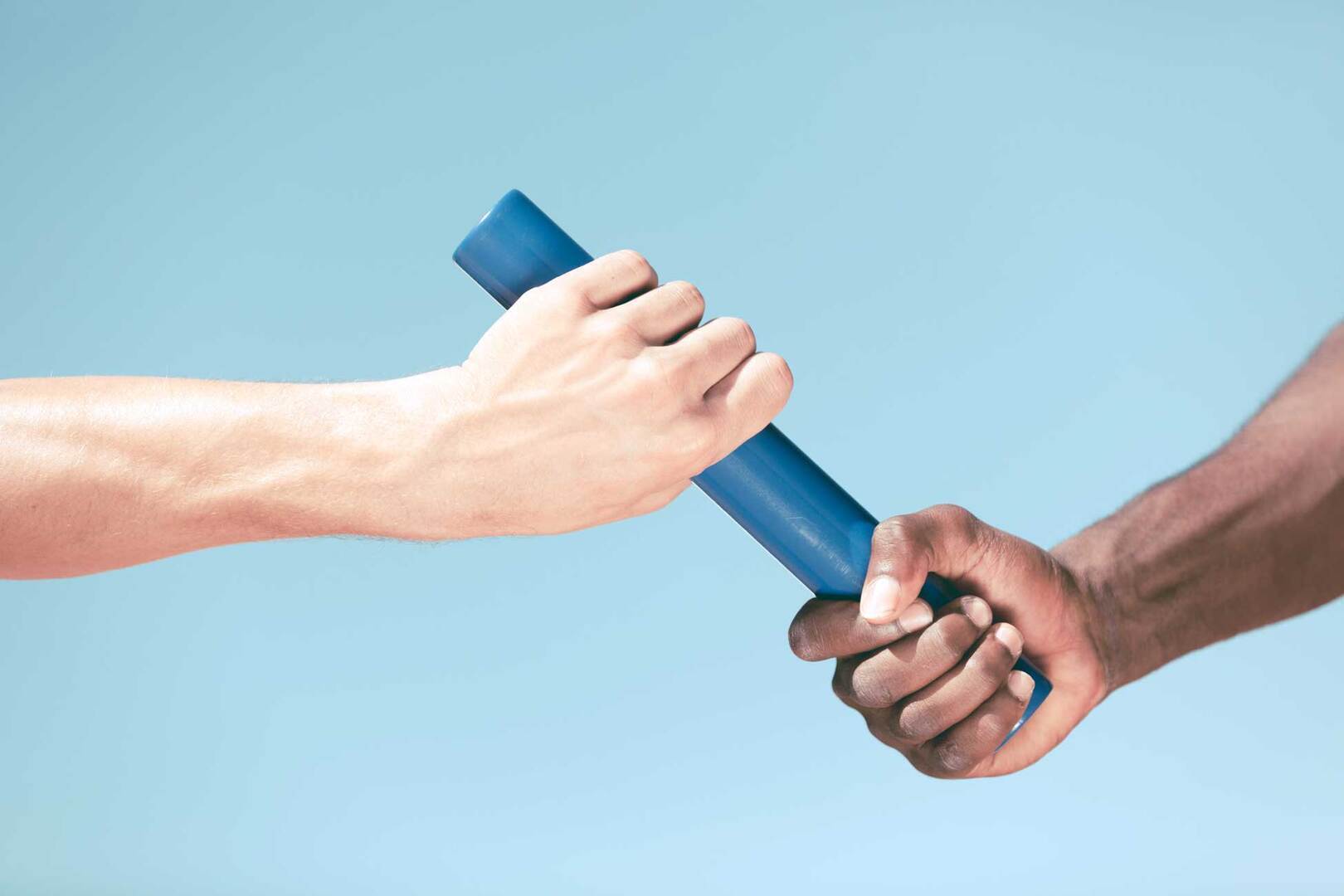 Close up of two hands passing a baton in a race