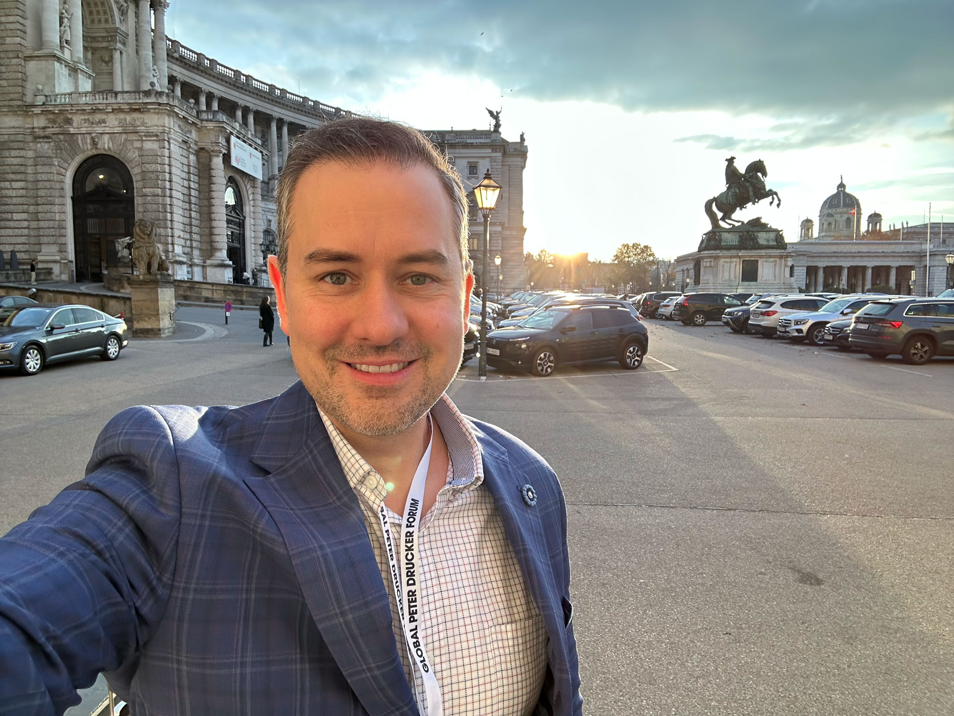 Justin Brady, Drucker Forum TV Host standing in front of Hofburg Palace in Vienna, Austria