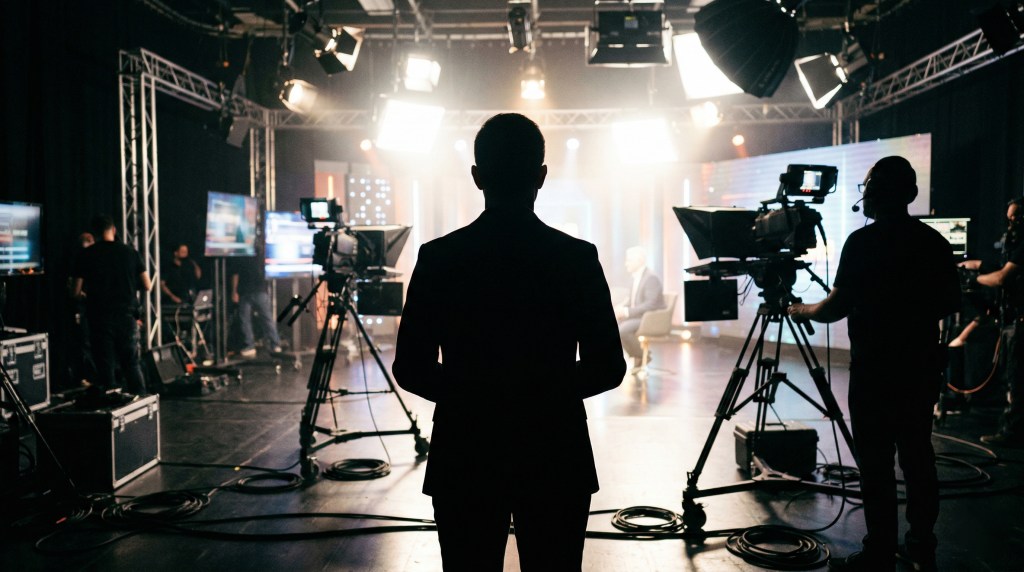 Silhouette of a person waiting to go on a TV interview. This image is Ai generated.